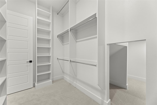 walk in closet featuring light carpet