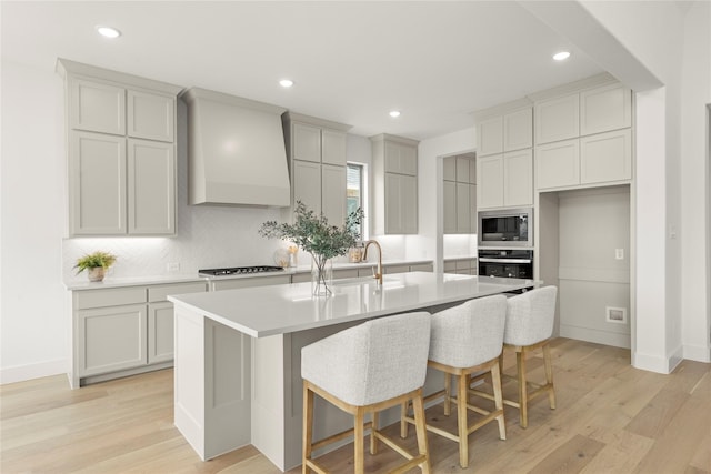 2671 Pelican Pt, Prosper, TX 75078 - kitchen with a sink, custom range hood, appliances with stainless steel finishes, tasteful backsplash, and an island with sink