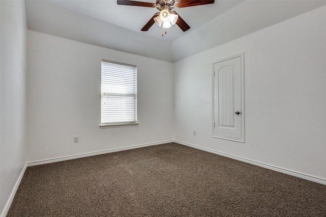 spare room featuring dark colored carpet and ceiling fan