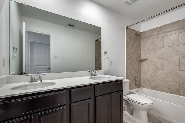 full bathroom featuring tile patterned flooring, vanity, toilet, and tiled shower / bath