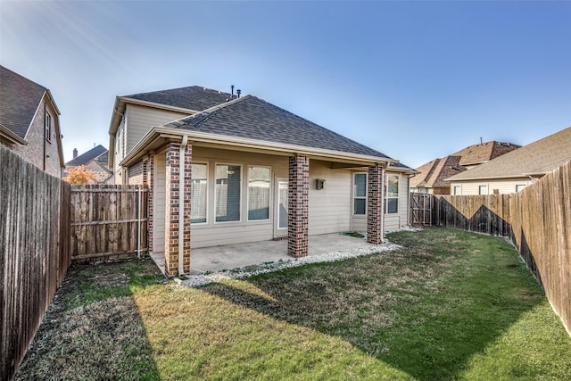 rear view of house with a yard and a patio area