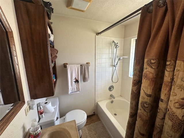 full bathroom with shower / bath combo, toilet, a textured ceiling, and vanity