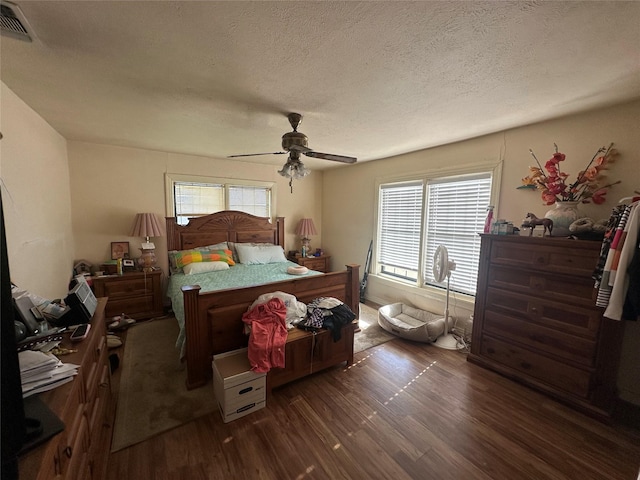 bedroom featuring a textured ceiling, ceiling fan, and dark wood-type flooring