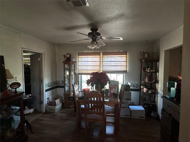 dining space featuring a textured ceiling, ceiling fan, and dark wood-type flooring