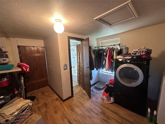 washroom with washer / dryer, light wood-type flooring, and a textured ceiling