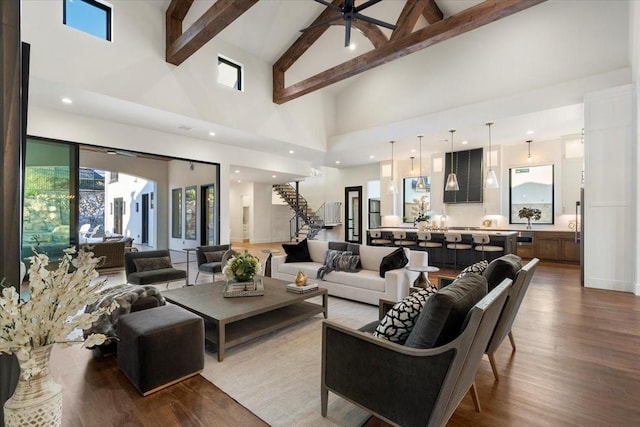 living room with hardwood / wood-style floors, ceiling fan, beamed ceiling, and high vaulted ceiling