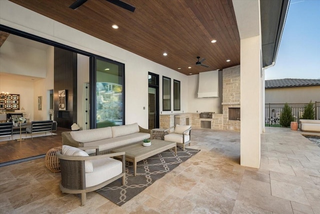 view of patio / terrace featuring an outdoor living space with a fireplace, ceiling fan, exterior kitchen, and grilling area