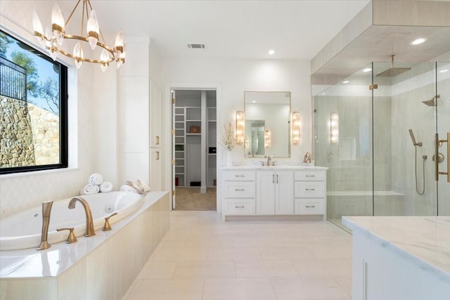 bathroom featuring tile patterned flooring, an inviting chandelier, vanity, and shower with separate bathtub