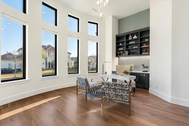 dining area with a wealth of natural light, a towering ceiling, and dark hardwood / wood-style floors