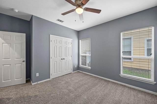 unfurnished bedroom with a closet, ceiling fan, and carpet flooring