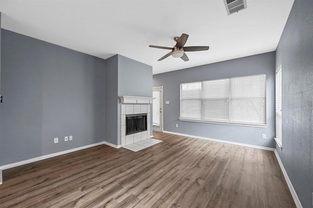 unfurnished living room with ceiling fan, hardwood / wood-style floors, and a fireplace