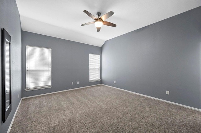 carpeted spare room featuring lofted ceiling and ceiling fan