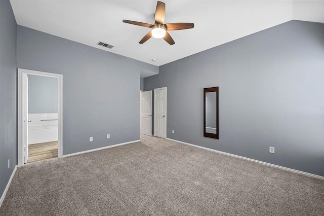 unfurnished bedroom with ensuite bath, carpet floors, ceiling fan, and vaulted ceiling