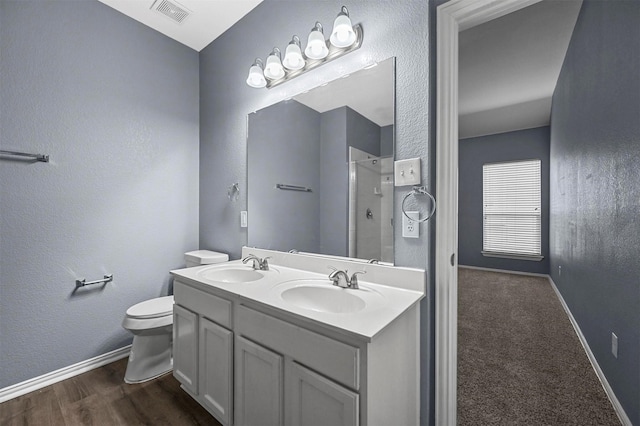 bathroom featuring vanity, toilet, an enclosed shower, and hardwood / wood-style floors