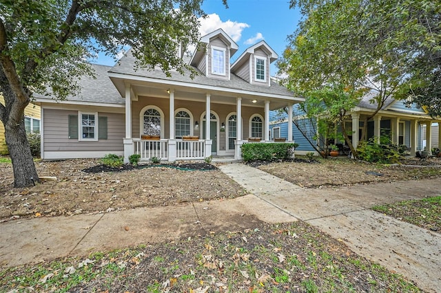 cape cod home featuring covered porch