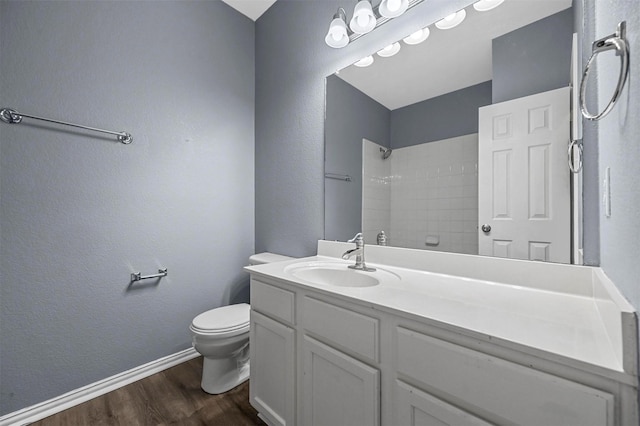 bathroom featuring hardwood / wood-style flooring, vanity, toilet, and a shower