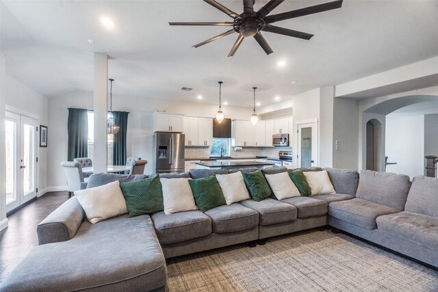 living room with french doors, light wood-type flooring, vaulted ceiling, ceiling fan, and sink