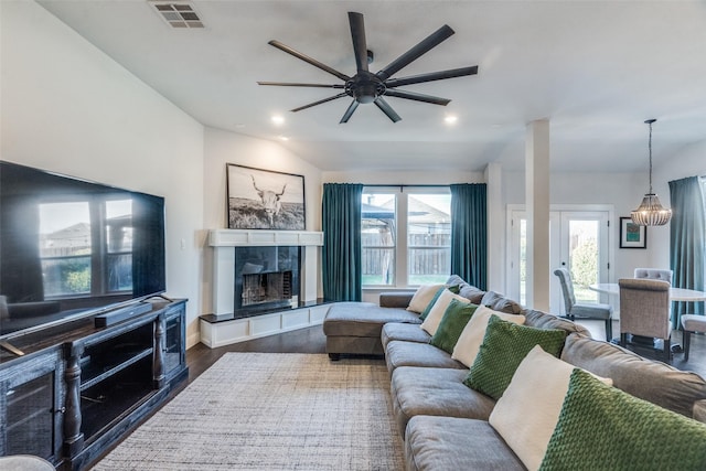 living room featuring ceiling fan, dark hardwood / wood-style flooring, and a fireplace