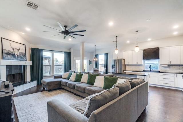 living room with ceiling fan, sink, and dark wood-type flooring