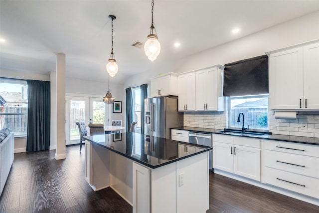 kitchen with decorative light fixtures, a wealth of natural light, white cabinetry, and appliances with stainless steel finishes