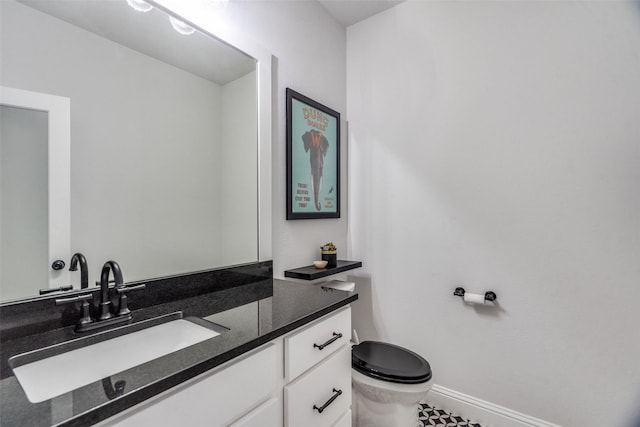 bathroom with tile patterned flooring, vanity, and toilet