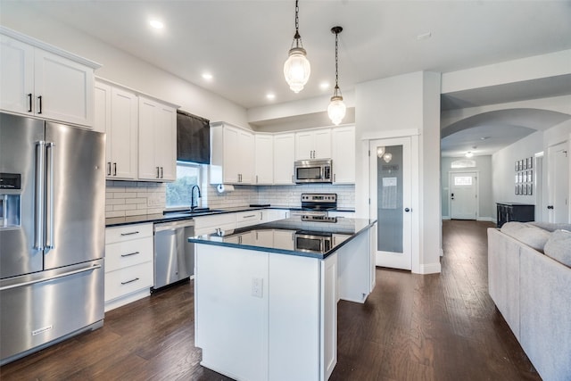 kitchen featuring stainless steel appliances, white cabinetry, a center island, and pendant lighting