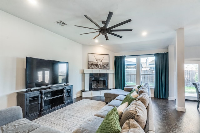 living room featuring dark hardwood / wood-style floors, vaulted ceiling, and ceiling fan