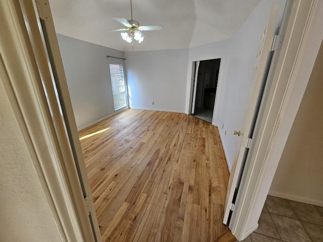 spare room with light wood-style floors, baseboards, and a ceiling fan