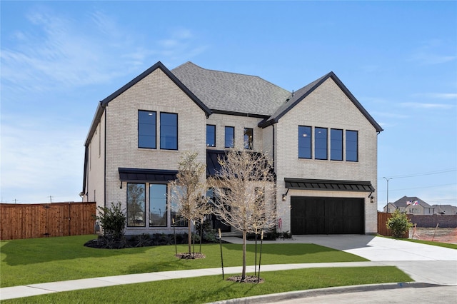 view of front facade featuring brick siding, concrete driveway, an attached garage, a front yard, and fence