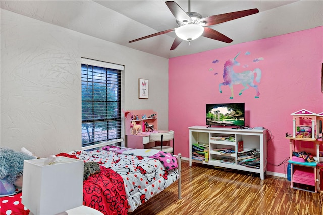 bedroom with a ceiling fan, baseboards, and wood finished floors