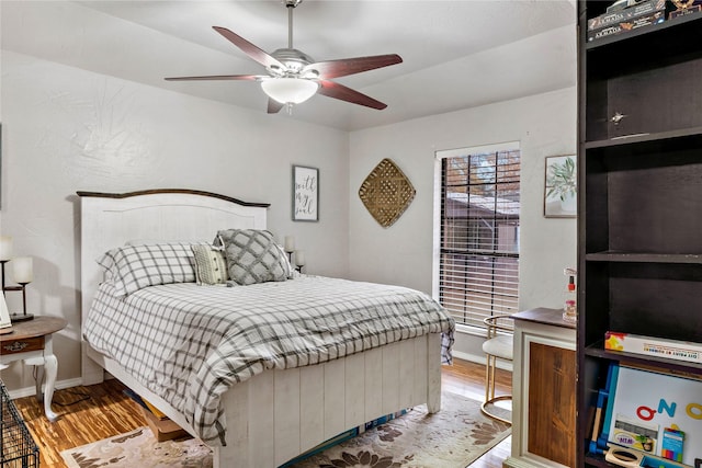 bedroom featuring a ceiling fan, baseboards, and wood finished floors