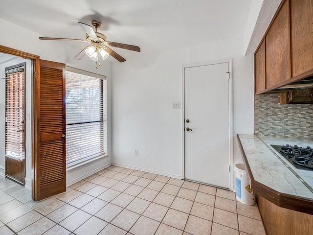 kitchen featuring white gas cooktop, decorative backsplash, ceiling fan, light tile patterned floors, and tile counters