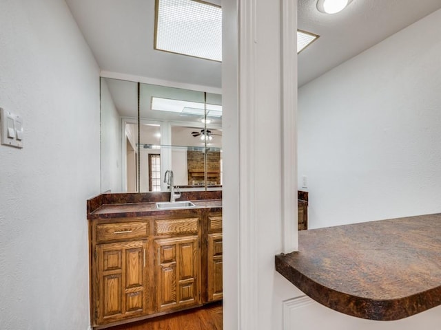 bathroom featuring ceiling fan, hardwood / wood-style floors, and vanity