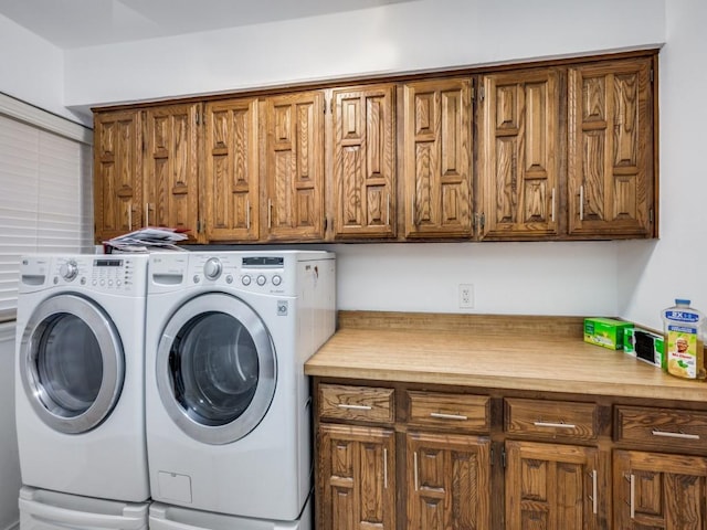 laundry room featuring washing machine and clothes dryer and cabinets