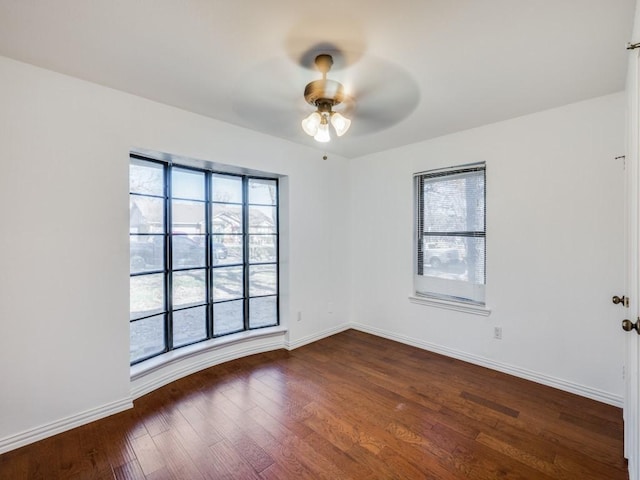 unfurnished room featuring dark hardwood / wood-style floors, plenty of natural light, and ceiling fan