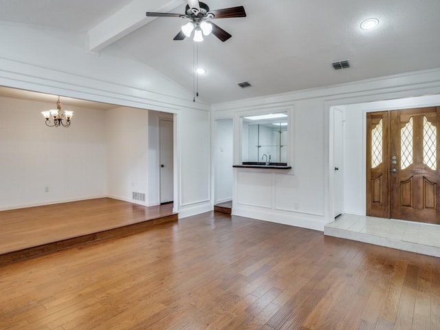 entrance foyer featuring ceiling fan with notable chandelier, hardwood / wood-style floors, and lofted ceiling with beams