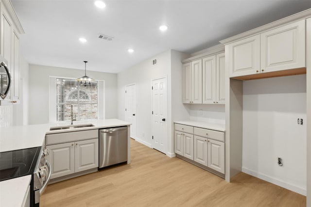 kitchen featuring white cabinetry, light hardwood / wood-style flooring, decorative light fixtures, and appliances with stainless steel finishes