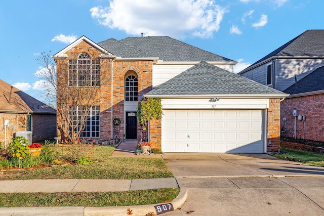 traditional-style home featuring roof with shingles, driveway, brick siding, and an attached garage