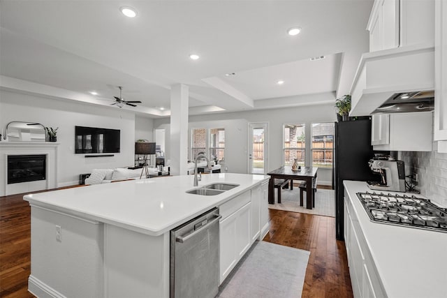 kitchen with ceiling fan, sink, stainless steel appliances, a kitchen island with sink, and white cabinets