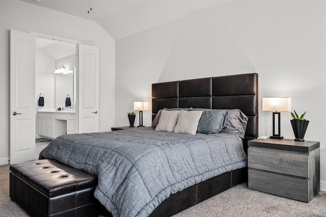 bedroom with carpet flooring, ensuite bathroom, and vaulted ceiling