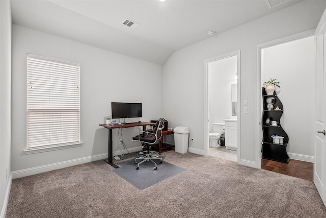 office space with light colored carpet and lofted ceiling