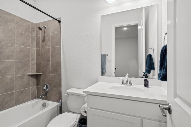 full bathroom featuring vanity, tiled shower / bath combo, and toilet