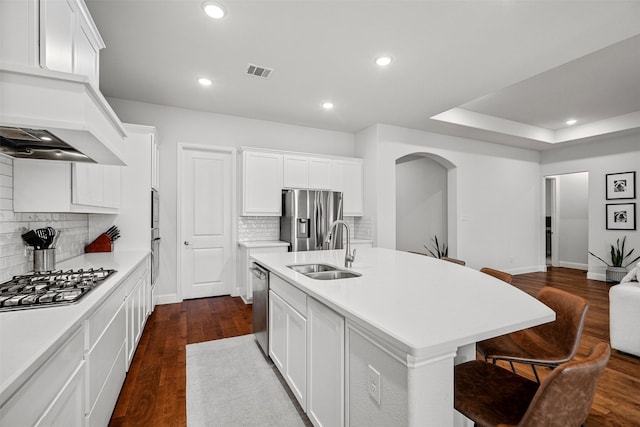 kitchen featuring white cabinets, a center island with sink, stainless steel appliances, and sink