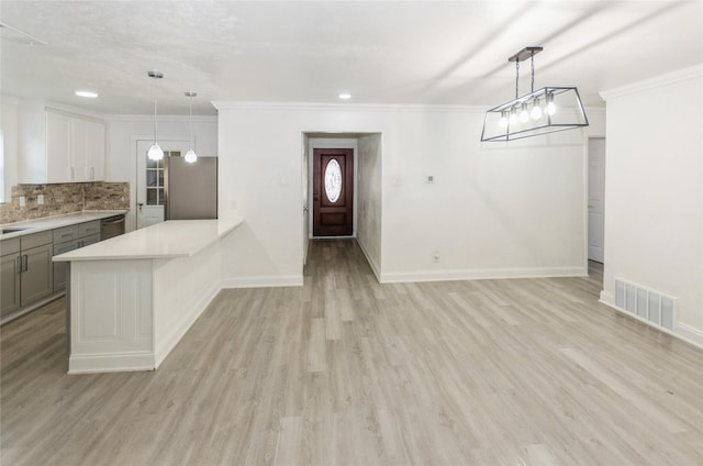 unfurnished dining area with light wood-style flooring, crown molding, visible vents, and baseboards