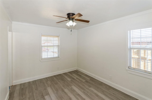 spare room featuring ornamental molding, wood finished floors, a ceiling fan, and baseboards