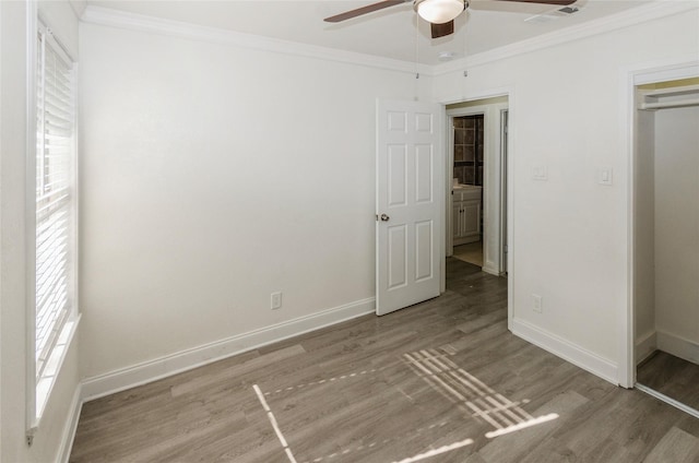 unfurnished bedroom featuring wood-type flooring, ornamental molding, a closet, and ceiling fan