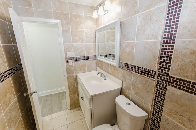 bathroom with tile walls, vanity, tile patterned floors, and toilet