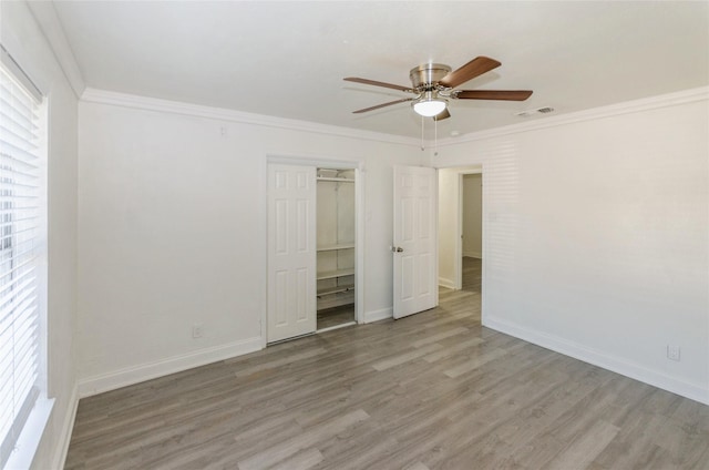 unfurnished bedroom with ceiling fan, ornamental molding, light hardwood / wood-style floors, and multiple windows