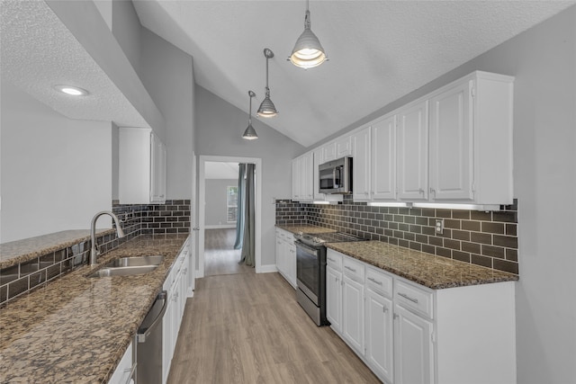 kitchen featuring sink, a textured ceiling, decorative light fixtures, white cabinets, and appliances with stainless steel finishes