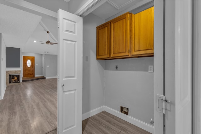 laundry area featuring electric dryer hookup, ceiling fan, cabinets, and light wood-type flooring